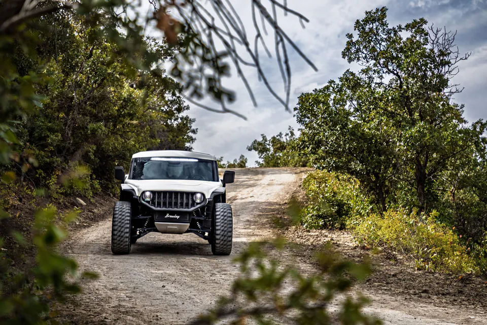 Brawley climbing a gravel two-track through scrub